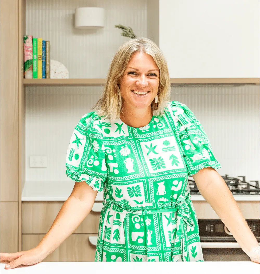 Sara Cornish, owner and interior designer at YUZU Interiors, smiling in a kitchen